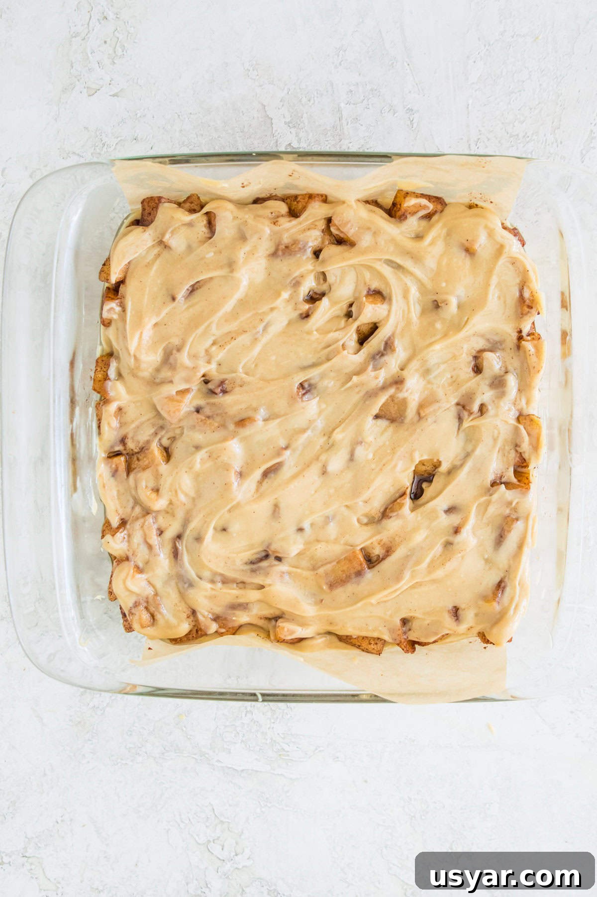 Gluten-Free Vegan and Paleo Apple Pie Bars 10 A square baking pan with cooked apples topped with caramel in it.
