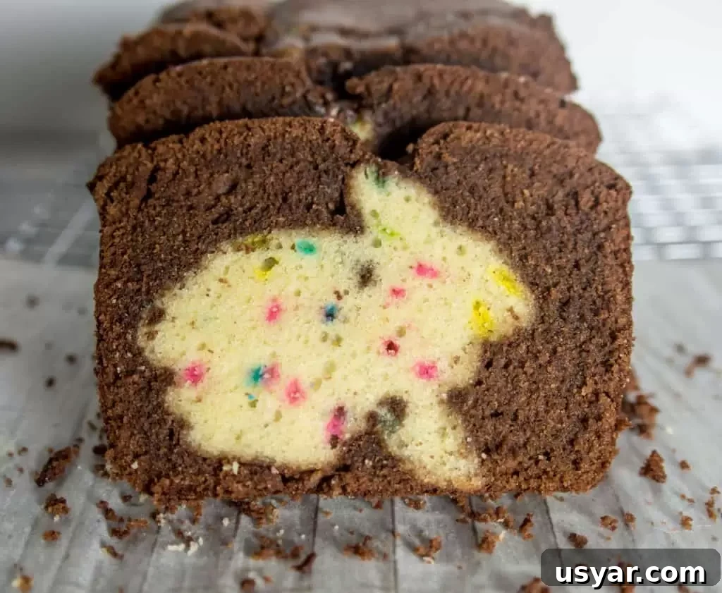 Chocolate Funfetti Cake with Hidden Bunny Inside 2 slices of chocolate funfetti hidden bunny cake sitting on a wire rack