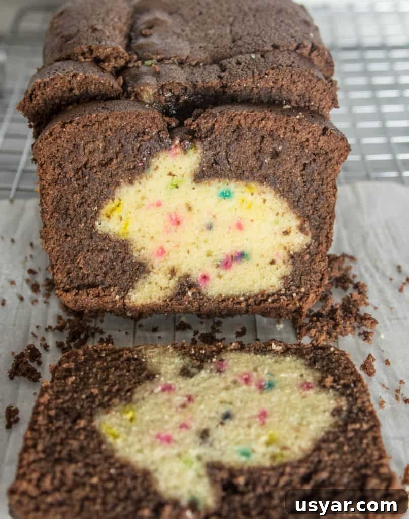 Chocolate Funfetti Cake with Hidden Bunny Inside 6 slices of chocolate funfetti hidden bunny cake sitting on a piece of parchment on top of a wire rack