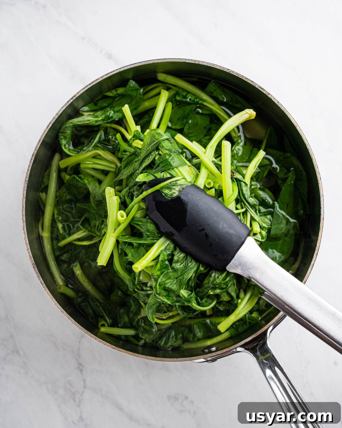 Vietnamese Garlic Water Spinach Stir Fry 7 Pot of boiling water with tongs holding up blanched rau muong.