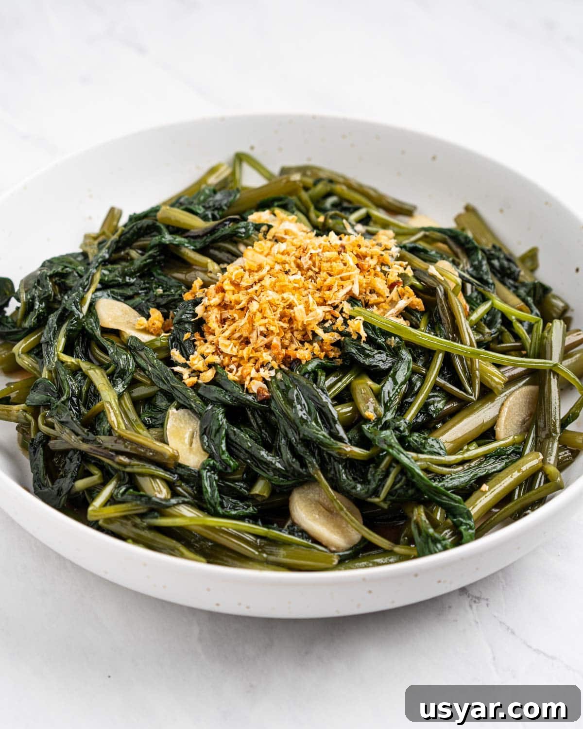 Vietnamese Garlic Water Spinach Stir Fry 10 Plate of water spinach stir fried with garlic slices and topped with fried garlic.