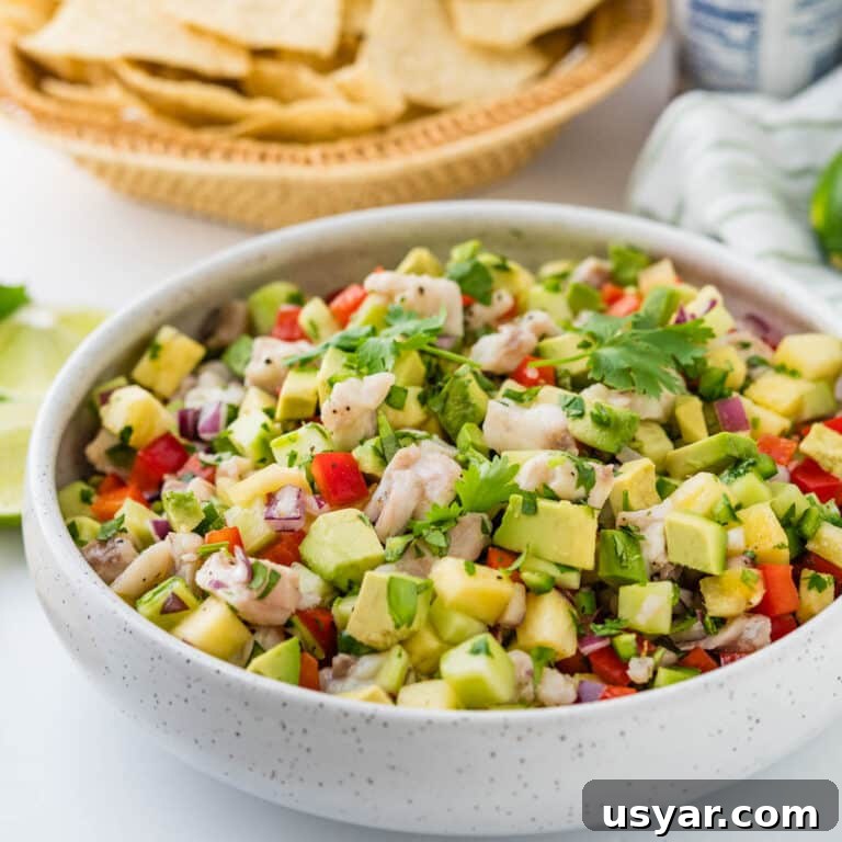 Fresh ceviche in a white bowl with tortilla chips.