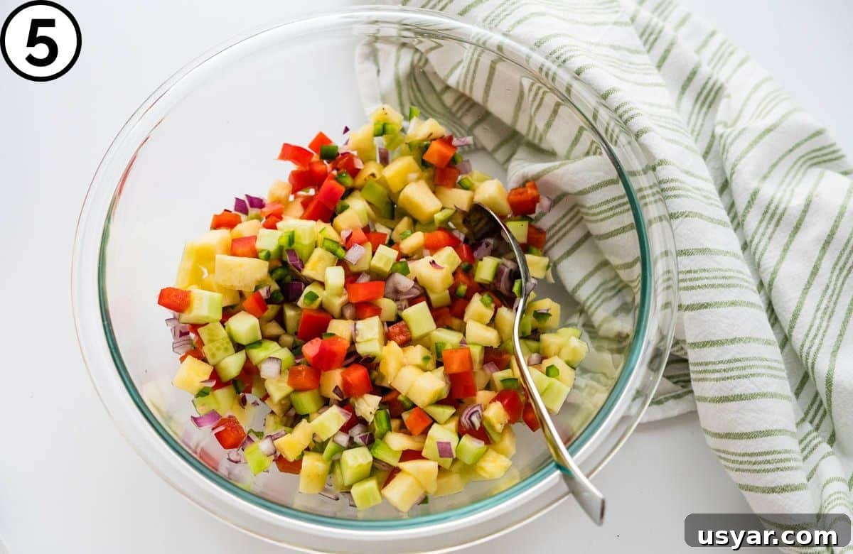 Combining chopped veggies in a bowl. 