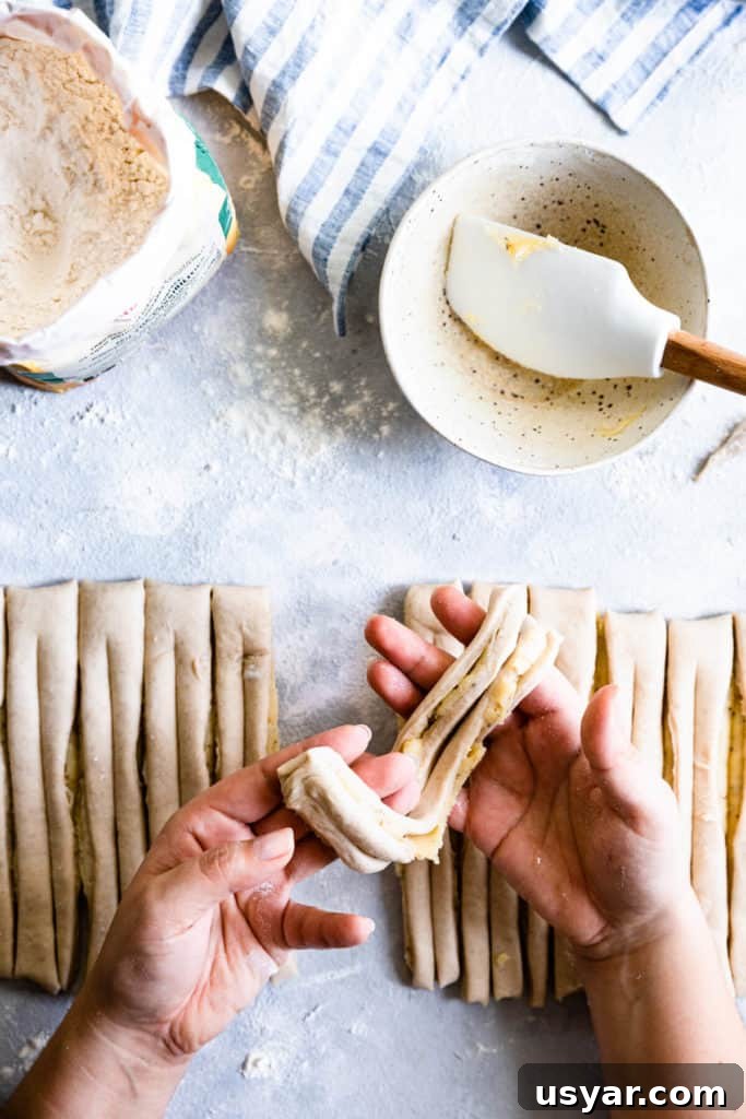 Swedish Cardamom Buns Recipe 11 top view of a person holding a strip of dough