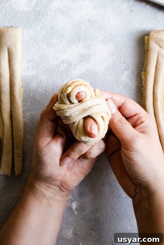 Swedish Cardamom Buns Recipe 16 top view of hands shaping the dough into knot
