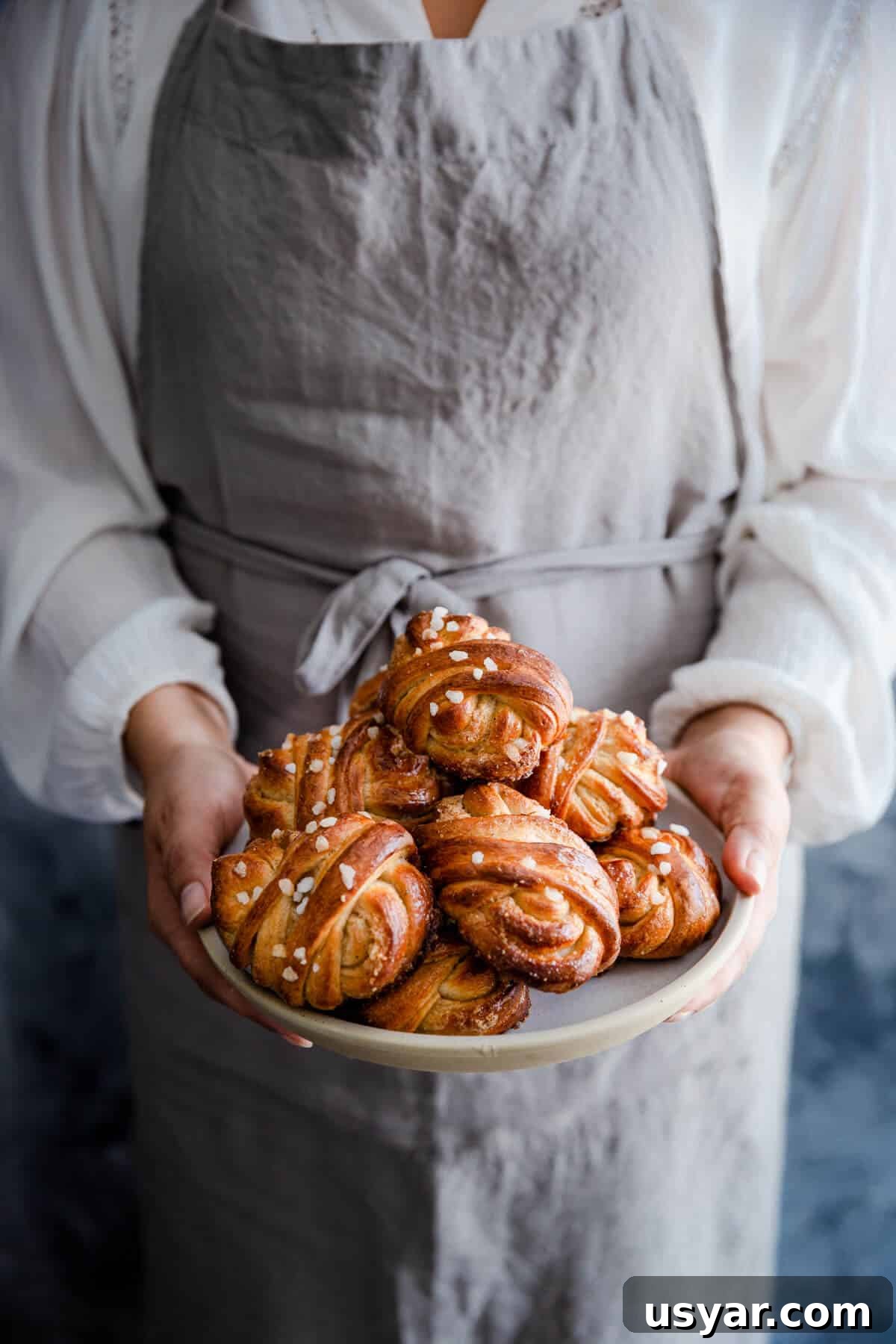 Swedish Cardamom Buns Recipe 3 straight ahead shot of a person holding a plate with buns
