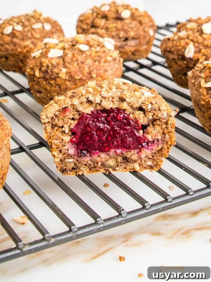 Oatmeal muffins, filled with jam, cooling on a wire rack.