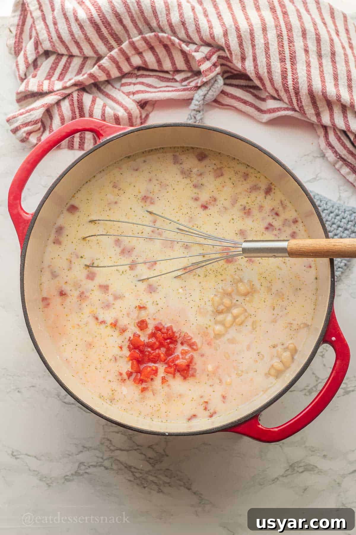 Tuscan Tortellini Soup with Tomatoes and White Beans 5 Tomatoes in soup pot with wooden spoon.