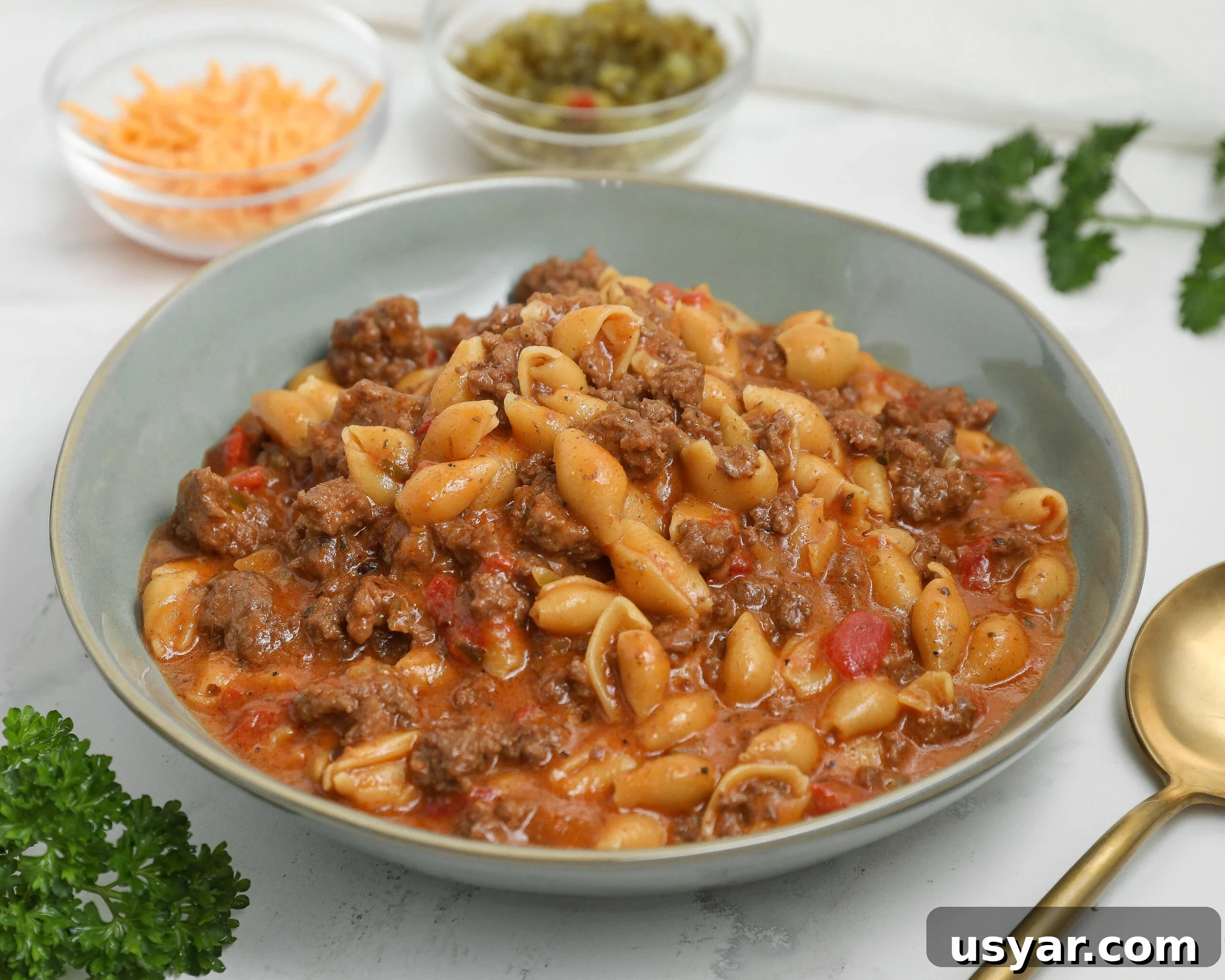 Bowl of cheeseburger pasta with shell pasta, ground beef, and a cheesy tomato-based sauce