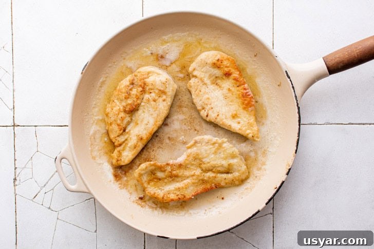Chicken pan frying in a skillet.
