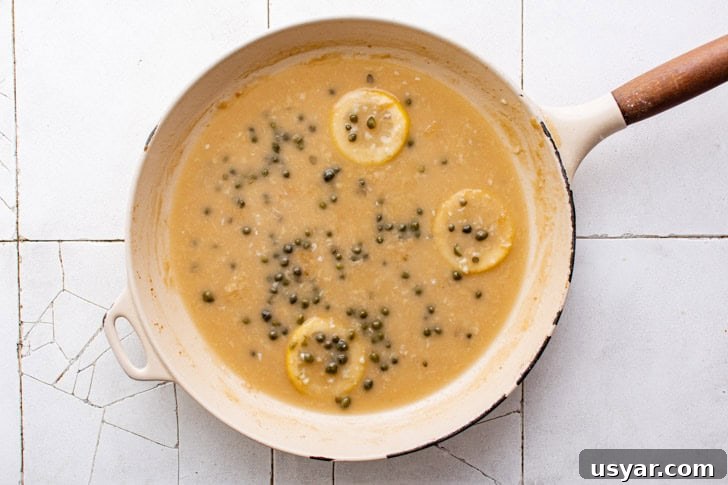 Capers added to a pan of lemon sauce.