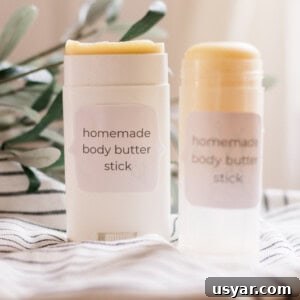Two body butter sticks on white and black stripe towel.