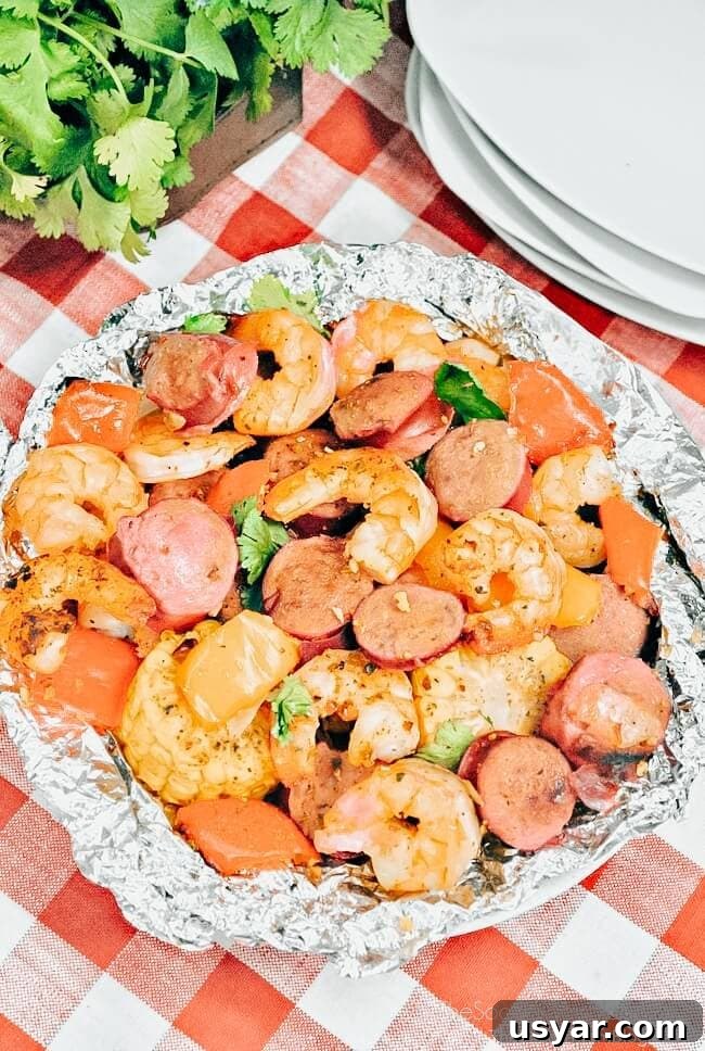 Cajun Shrimp Boil Foil Packets for Grill or Oven 4 foil packet filled with cajun seasoned shrimp, sausage, and vegetables