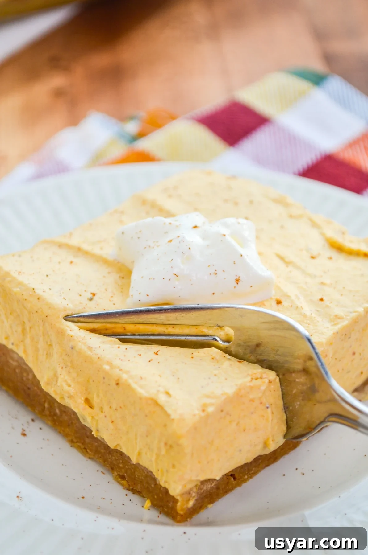 A fork sinking into a pumpkin cheesecake bar