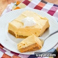 A fork with a portion of no bake pumpkin cheesecake bars.