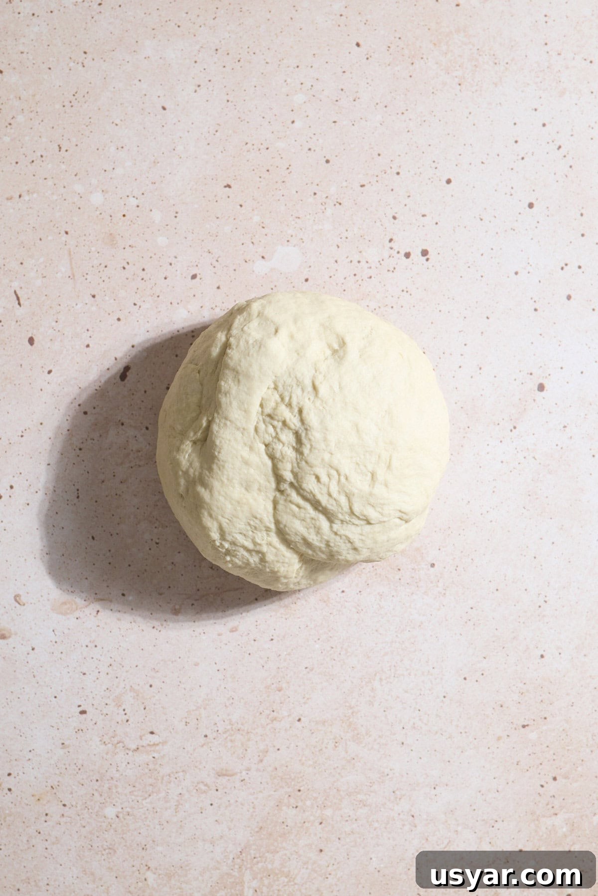 Smooth dough in a ball after kneading.