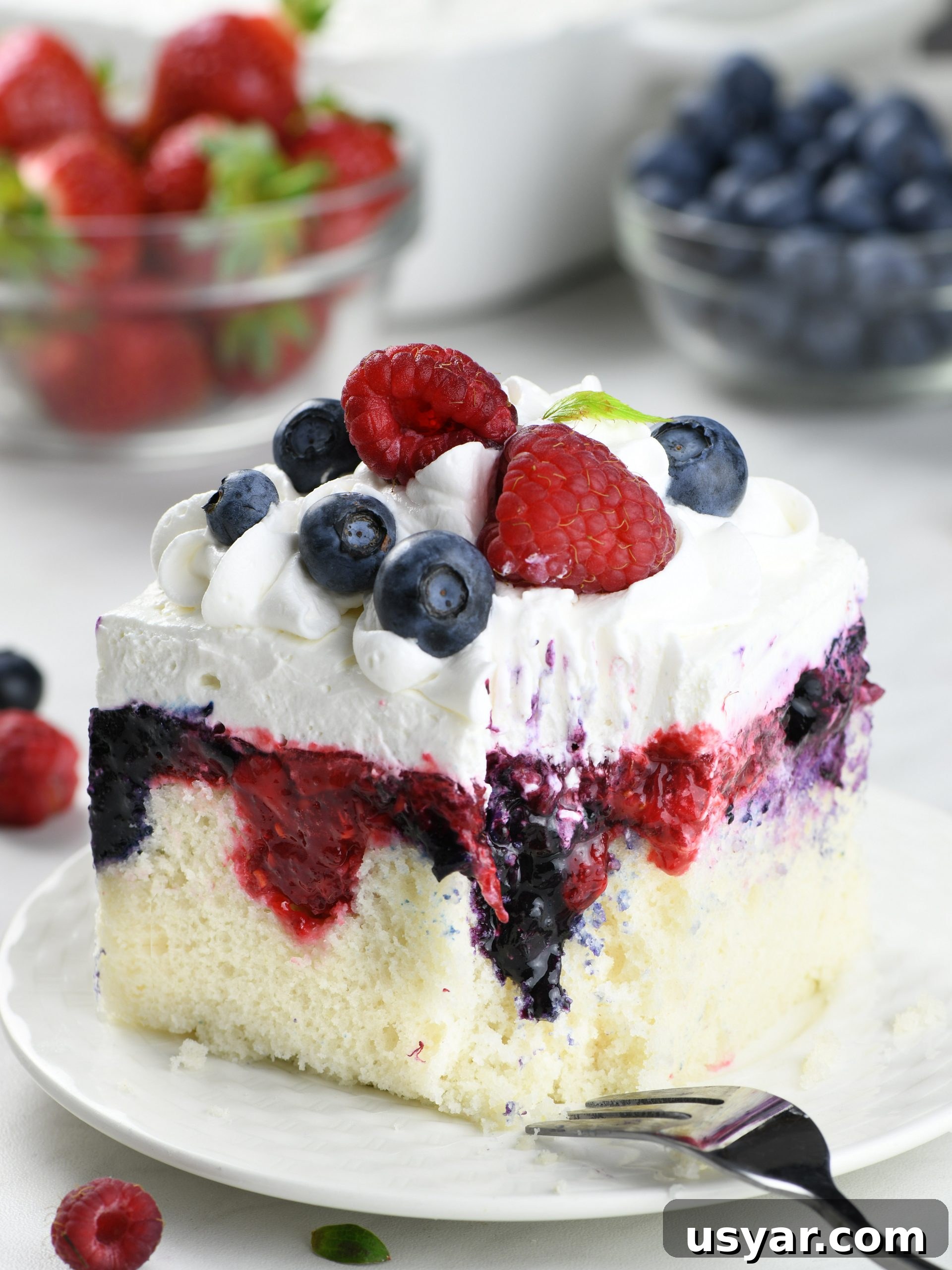 Summer Berry Poke Cake Recipe with Fresh Berries 3 Bursting with the fresh and vibrant flavors of summer, this Summer Berry Poke Cake effortlessly combines the sweet tartness of blueberries, strawberries, and raspberries, crowned with a light, airy whipped cream.