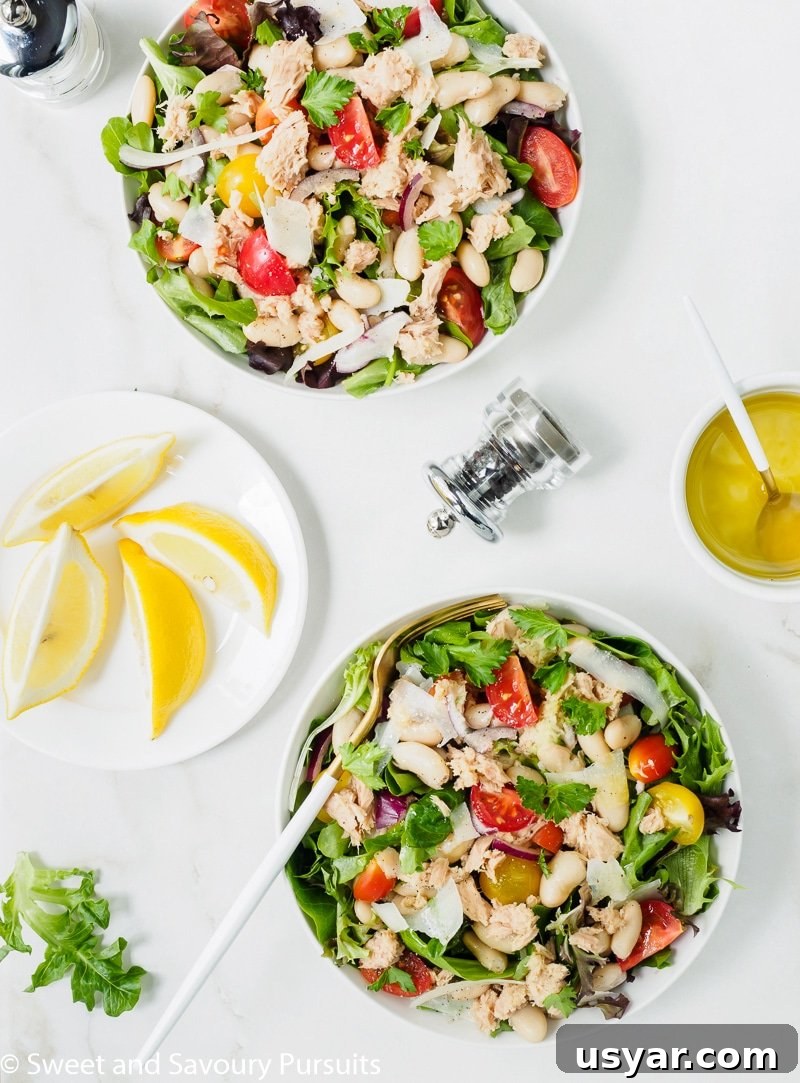 Mediterranean White Bean and Tuna Salad Recipe 2 Two bowls of white bean and tuna Salad with lemon and olive oil dressing served on the side.