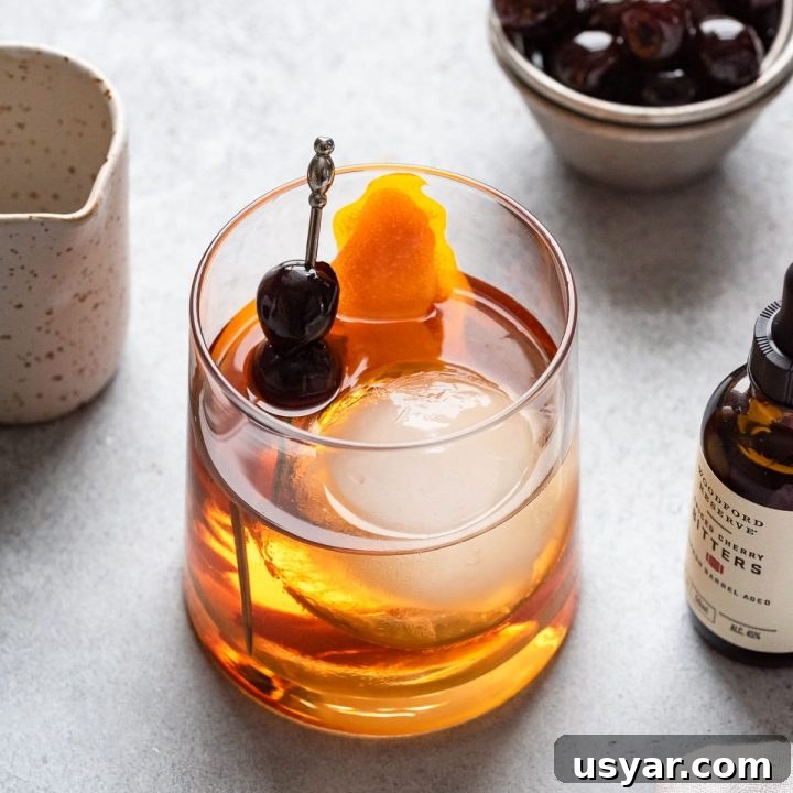 looking down at maple old fashioned with cherry and orange garnish