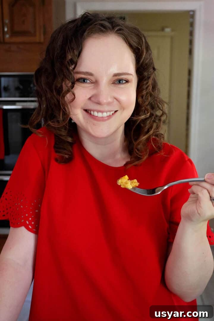 Cake Mix Peach Cobbler with Canned Peaches 11 Kelsey Smith holding a forkful of peach cobbler.