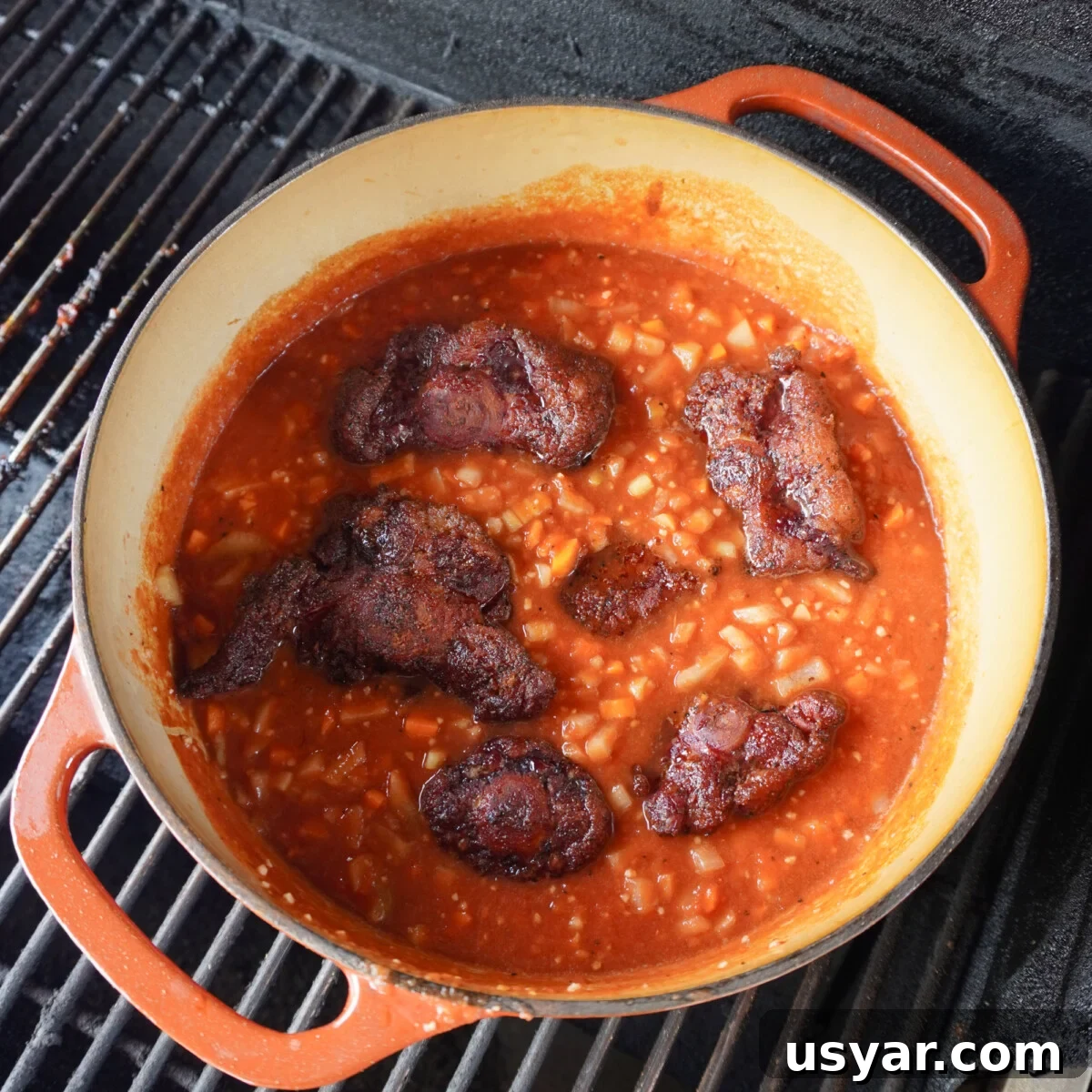 braising oxtail in a dutch oven on a smoker.