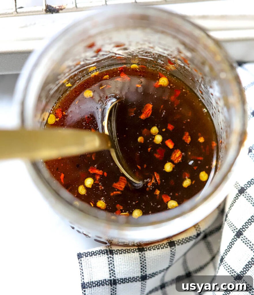 Hot honey stored in a glass jar with a spoon. 