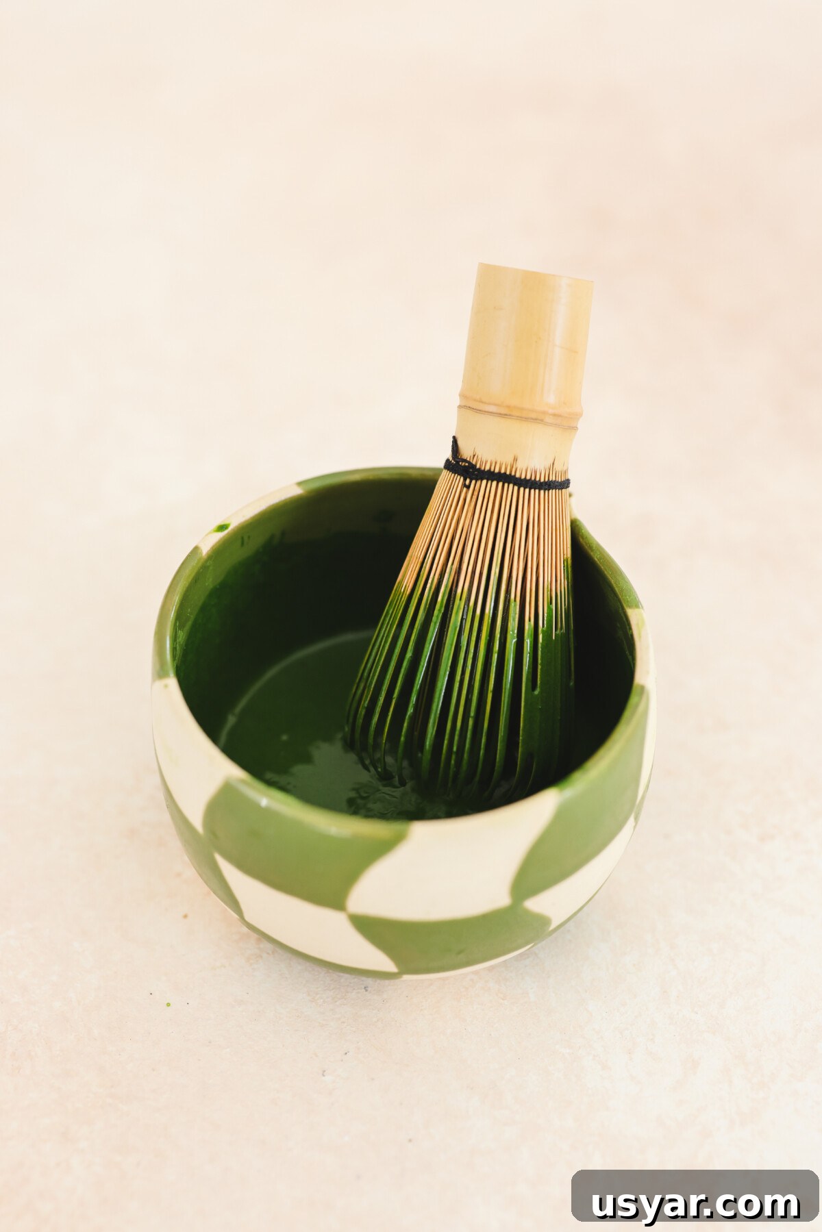 Vegan Matcha Butter Recipe: Sweet and Creamy Spread 4 a matcha bowl with a bamboo whisk