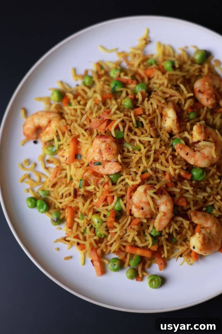 Quick Shrimp Curry Fried Rice Recipe 2 Curry fried rice with shrimp served on a white plate.