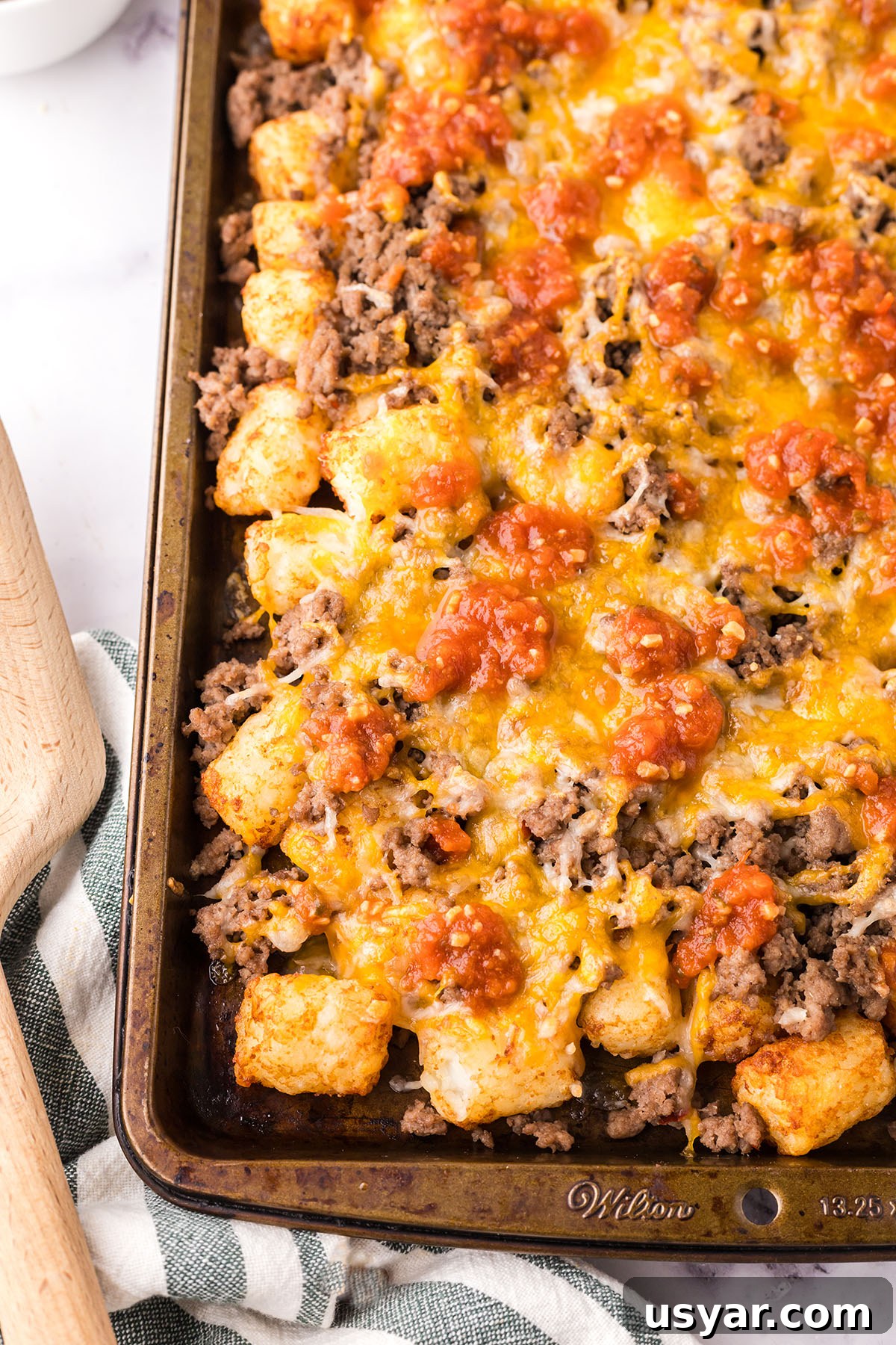 Mexican Totchos: Tater Tot Nachos with Pico and Cheese 9 Mexican Totchos on a sheet pan topped with salsa.
