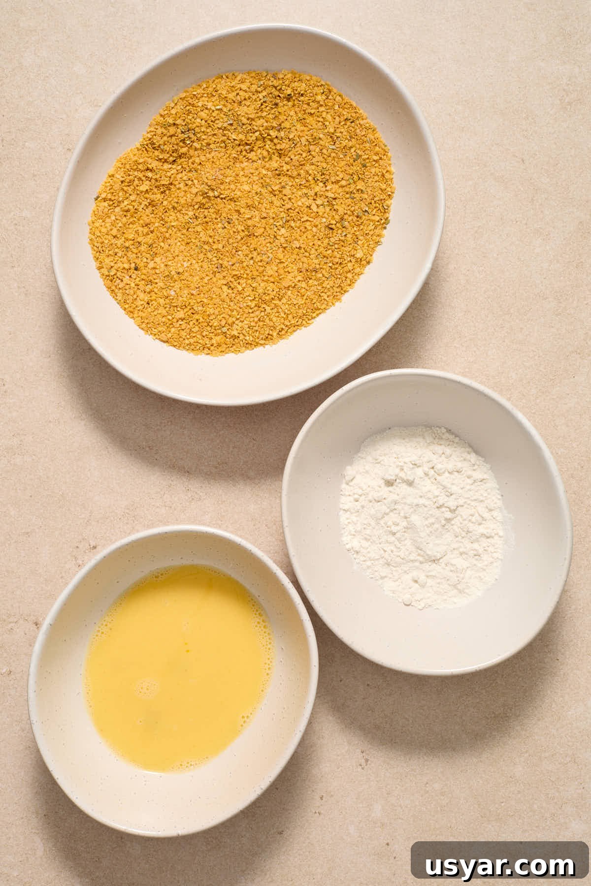 Breading stations set up in individual shallow bowls.