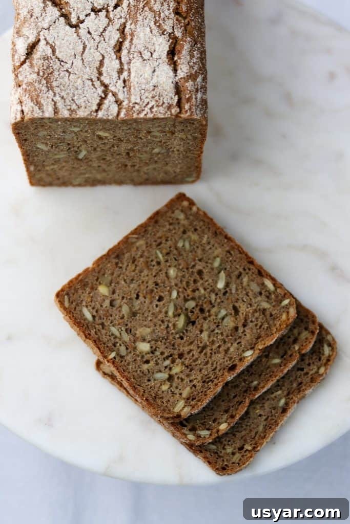 Danish Sourdough Rye Bread Rugbrød Recipe 4 Three rye bread slices next to a loaf of rye bread on a plate