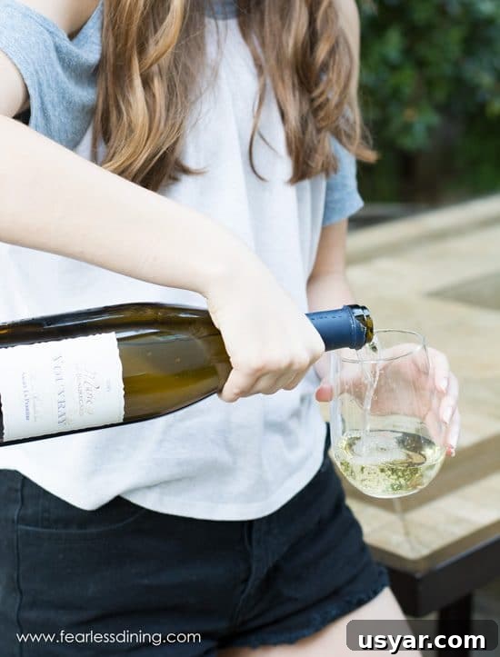Is Wine Gluten-Free? 3 A woman pouring white wine into a stemless wine glass she is holding.