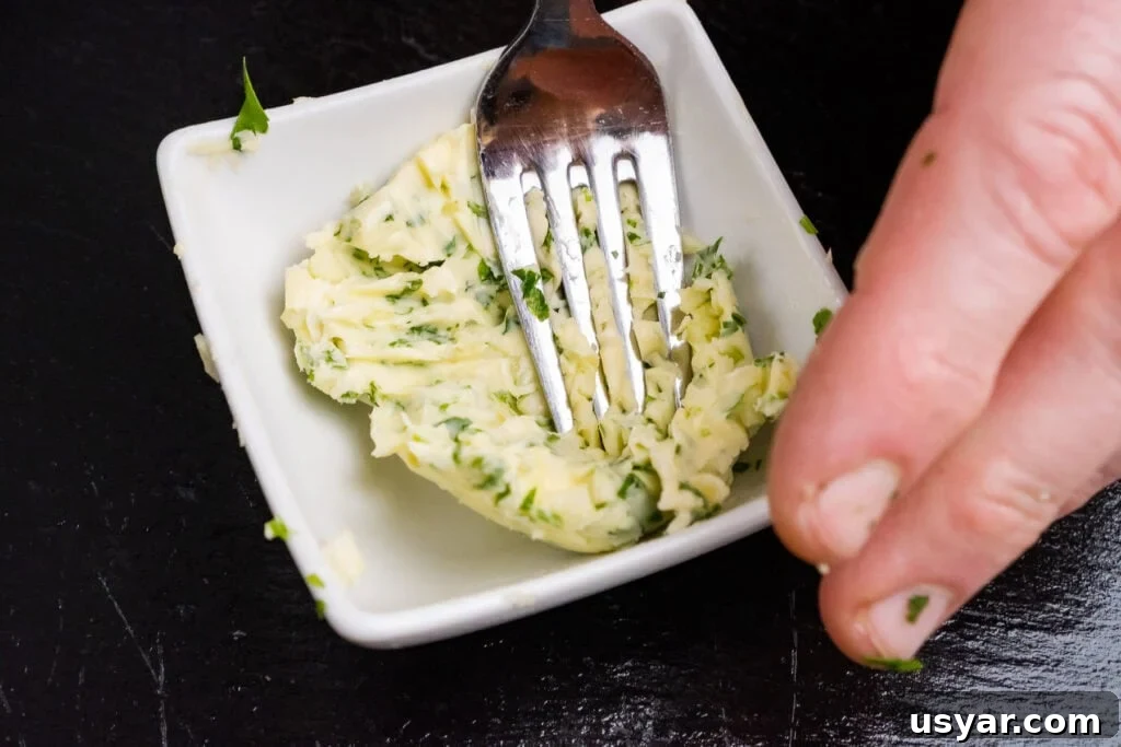 Mixing garlic butter together with a fork