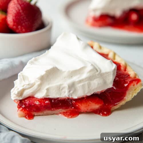 Creamy Banana Pudding Recipe with Sour Cream 12 slice of strawberry jello pie topped with whipped topping on a white plate.