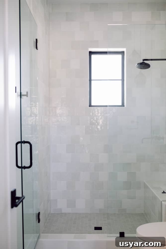 Shower with white Cloe tile and black hardware with grey accents.
