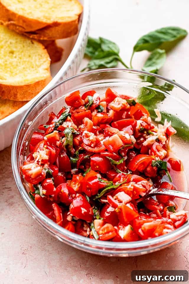 Tomato salad next to toasted garlic bread. tomato salad in a salad bowl set next to toasted garlic bread