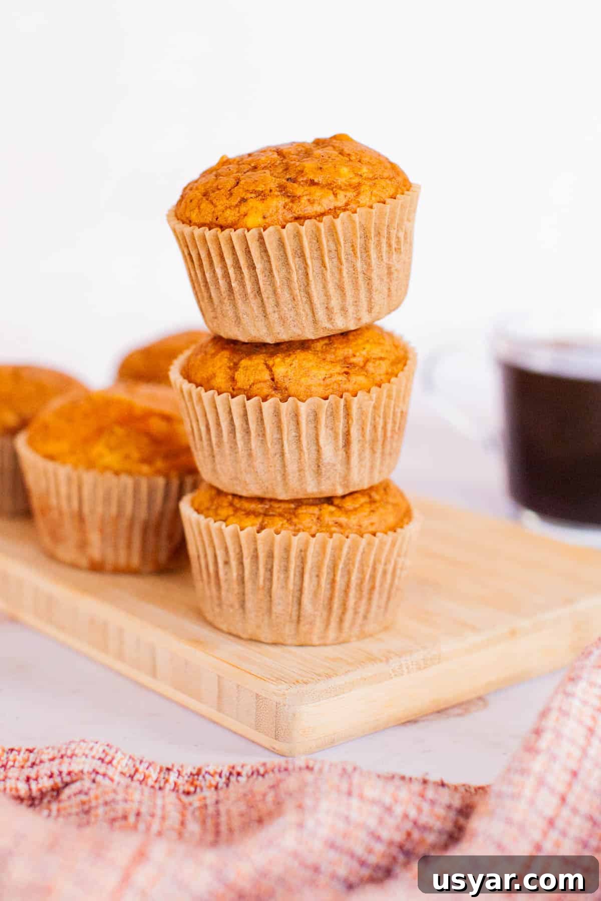 Moist Pumpkin Spice Muffins Recipe 2 Three pumpkin muffins stacked on top of each other.