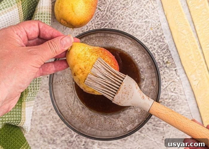 Crispy Honey-Glazed Pears in the Air Fryer 3 Pastry brush glazing melted butter and brown sugar mixture onto a pear.
