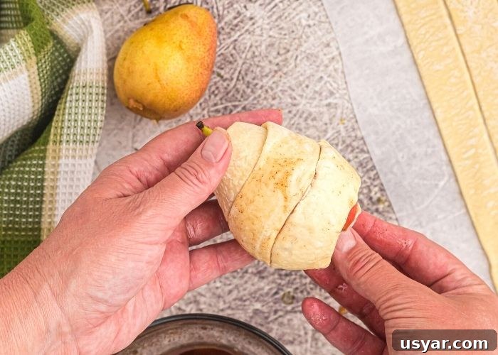 Crispy Honey-Glazed Pears in the Air Fryer 4 Strips of puff pastry wrapped around a pear, covering it before cooking it in the air fryer.