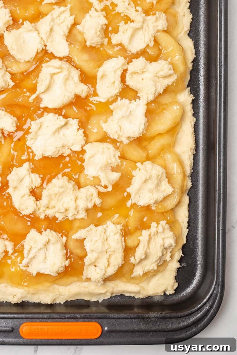 Cinnamon-Apple Pie Bars with Vanilla Glaze 7 Unbaked apple pie bars in jelly roll pan, ready to go into the oven.