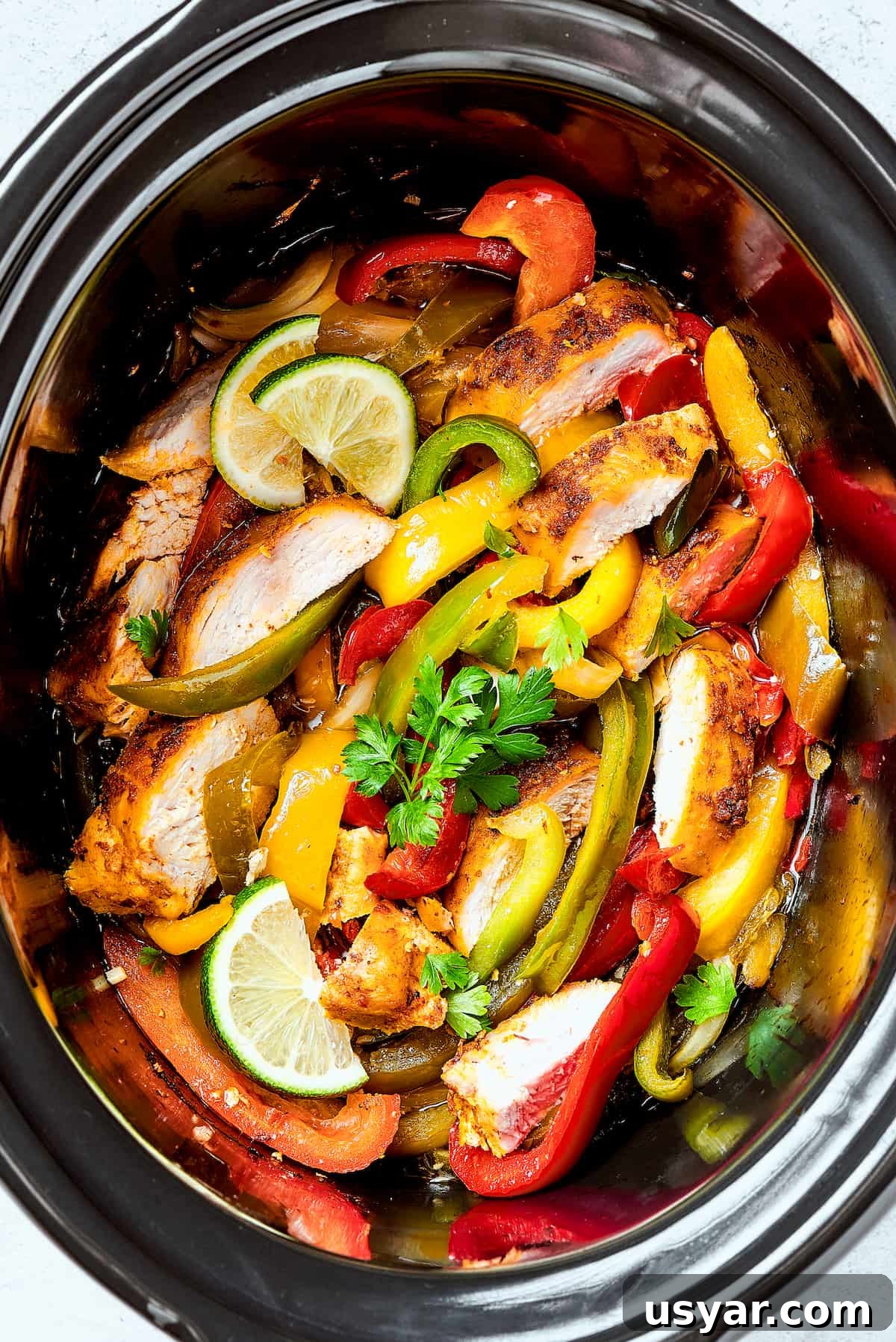These perfectly-seasoned Crockpot Chicken Fajitas are easy to make, perfect for busy days when you want a home-cooked meal without the hassle! Crockpot chicken fajitas in a slow cooker insert.