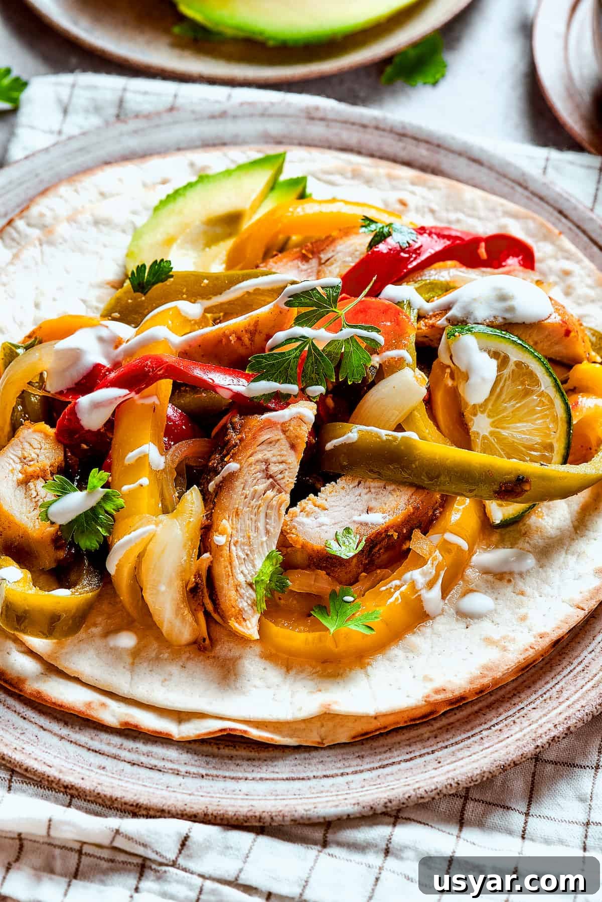 These perfectly-seasoned Crockpot Chicken Fajitas are easy to make, perfect for busy days when you want a home-cooked meal without the hassle! Homemade chicken fajitas with vegetables and lime slices.