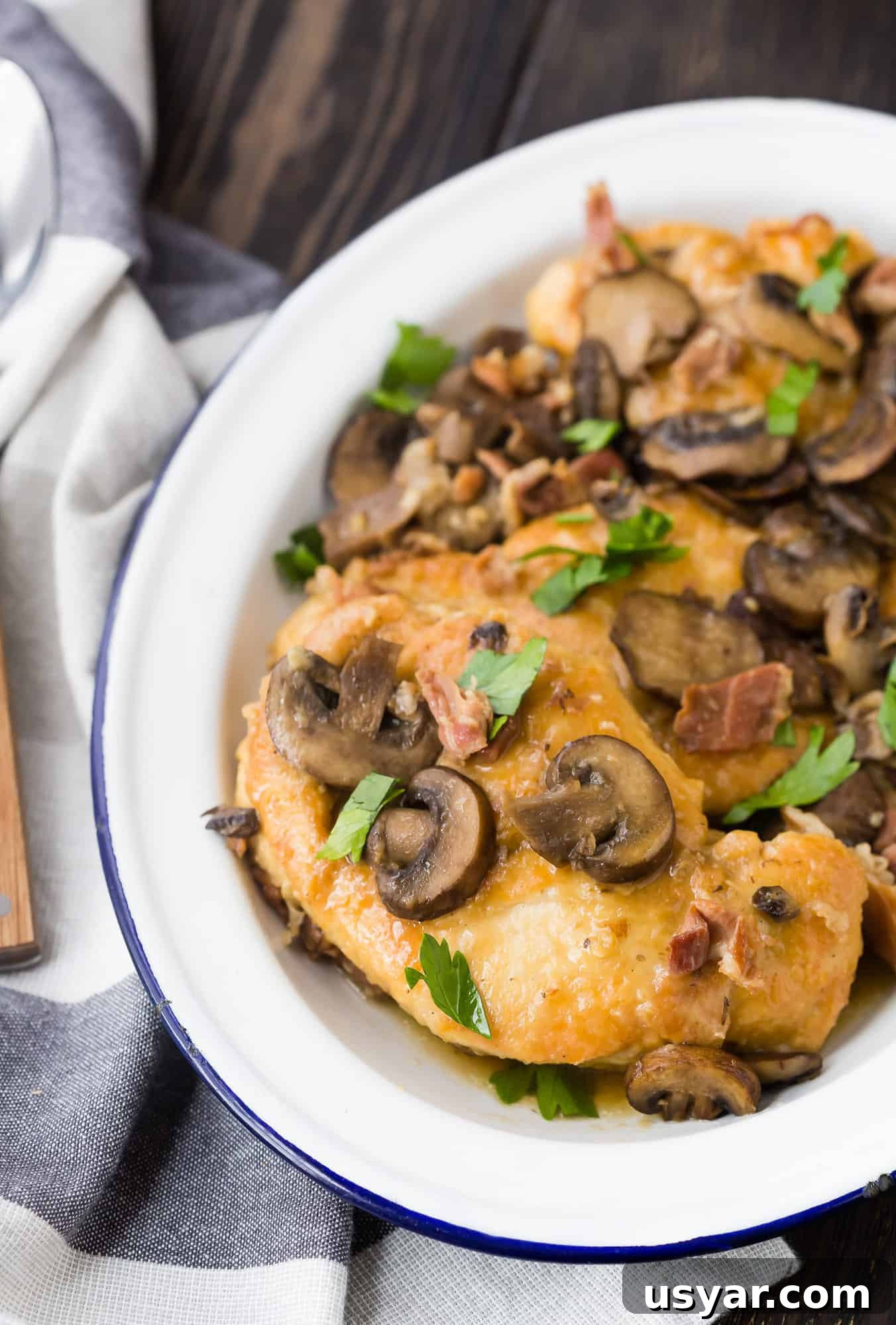 Instant Pot Chicken Marsala in 30 Minutes 3 Chicken with mushrooms and parsley on a white platter.
