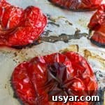 How to Roast Red Peppers at Home 5 Roasted red peppers shown on a foil-lined cookie sheet
