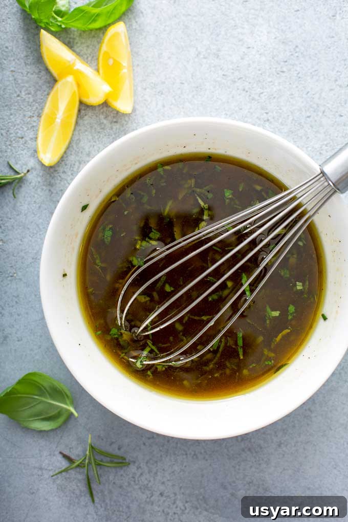 Tangy Balsamic Marinade for Chicken 5 A small white bowl with balsamic herb marinade and a whisk