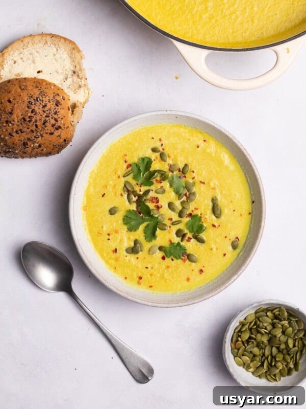 cauliflower soup served with bread rolls and pumpkin seeds.