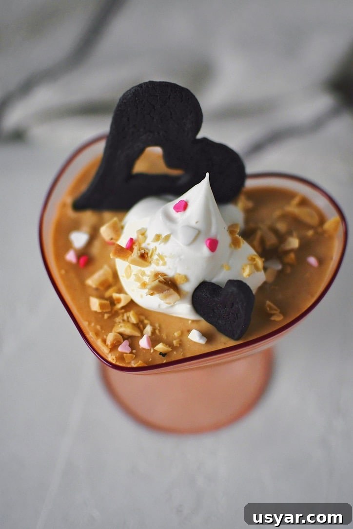 Decadent Peanut Butter Mousse Recipe 8 Peanut Butter Mousse in a small heart shaped cup, topped with whipped cream, peanuts, and a chocolate wafer.