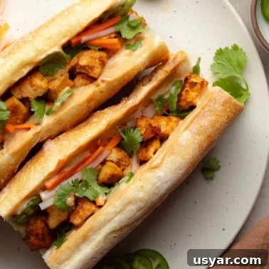 Vegan Banh Mi Sandwich with Pickled Vegetables 8 overhead view of two vegan banh mi sandwiches on a white plate.
