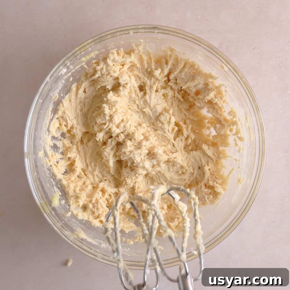 How to Make Chewy Salted Caramel Oatmeal Cookies 5 Butter, sugars, vanilla extract, and egg mixed in a bowl.