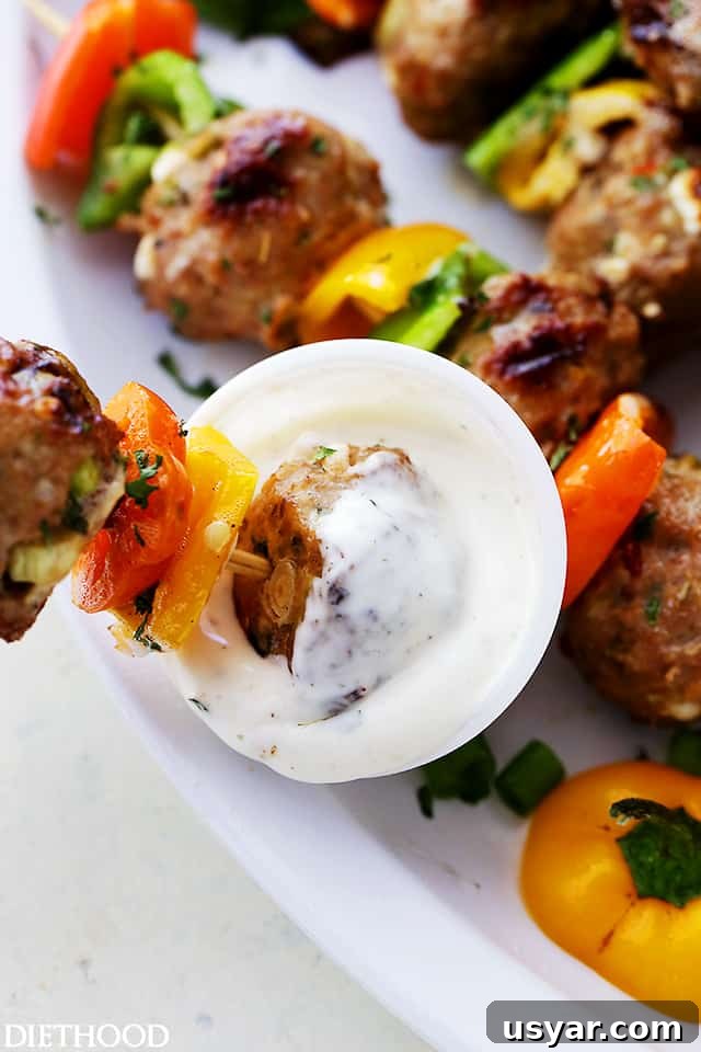 Grilled Turkey Meatball Skewers with Lemon Herb Glaze 6 Dipping a meatball skewer in yogurt sauce.